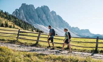 Coppia di escursionisti su un sentiero alpino davanti alle Dolomiti
