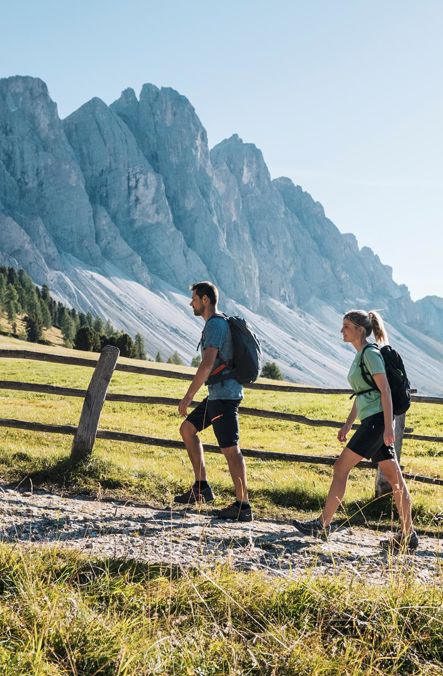 Hiking couple on an alpine path in front of the Dolomites