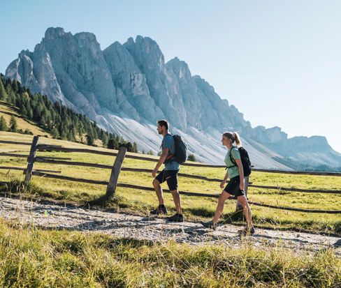 Coppia di escursionisti su un sentiero alpino davanti alle Dolomiti