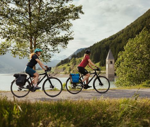 Ciclisti al Lago di Resia con il campanile di Curon