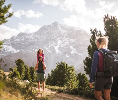 Famiglia in escursione con vista sulle montagne innevate